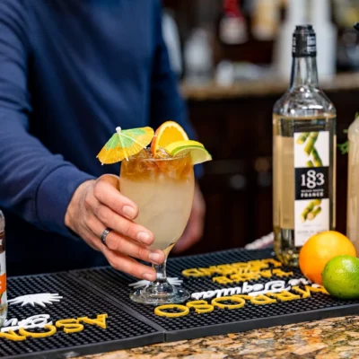Bartender serving a fresh citrus cocktail at Bistro 1969 bar