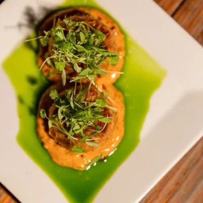 Gourmet appetizer with creamy sauce and microgreens served at Bistro 19